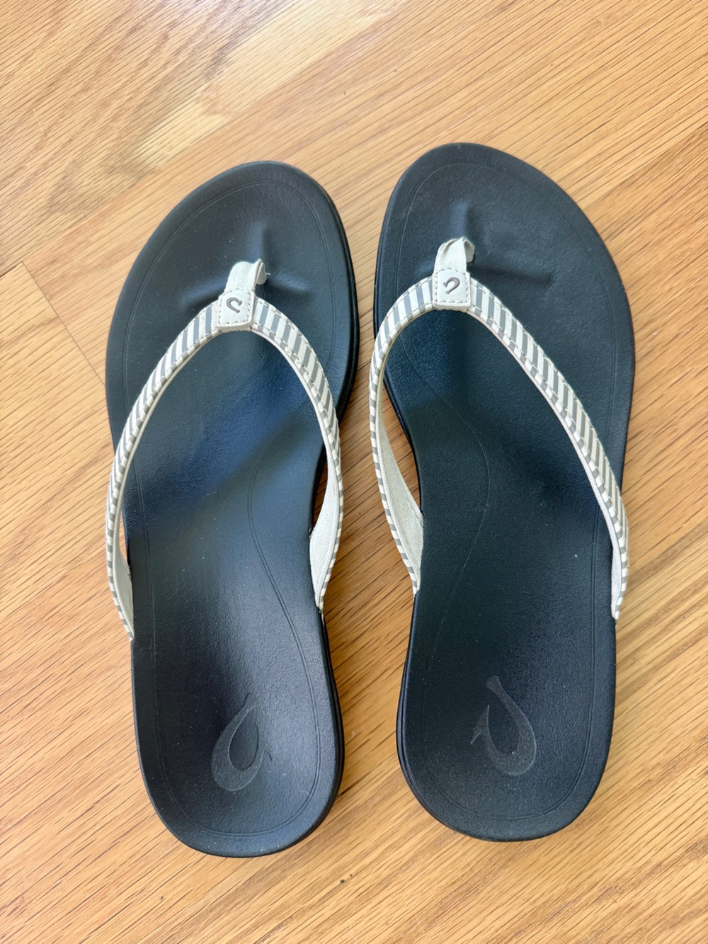 OluKai Black Footbed Flip Flop Sandals with Bone/Stripe Straps